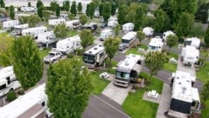Motorhomes and travel trailers parked in a wooded RV park covered by Extended RV Warranty